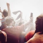 Lively crowd cheering and capturing moments at a sports event with energy and excitement.