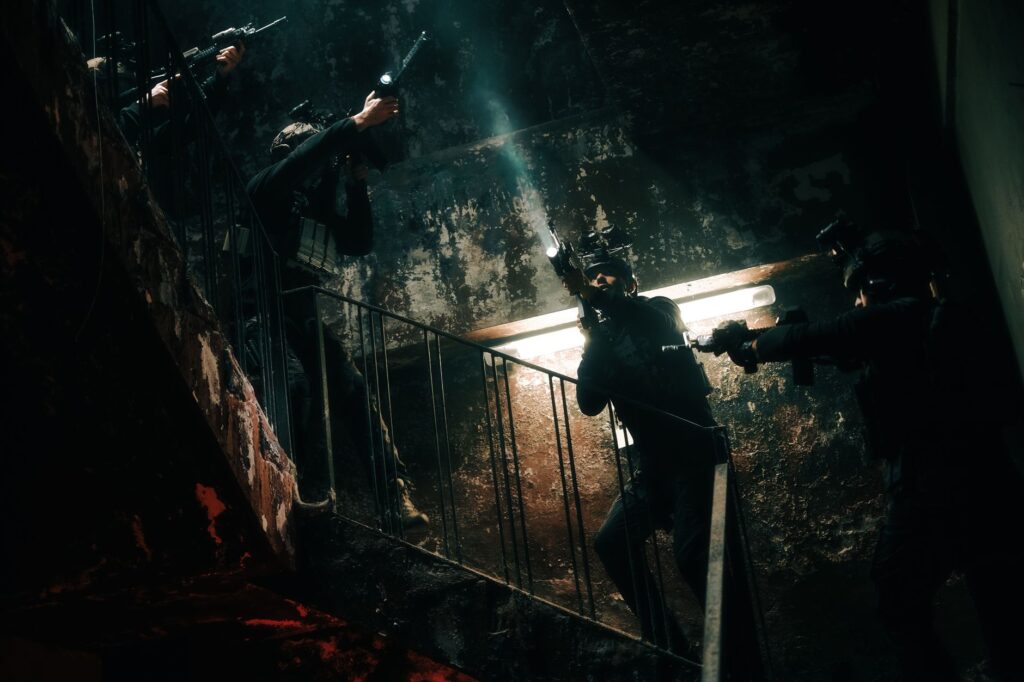 Special forces team conducting a tactical operation in a dimly lit, abandoned building.