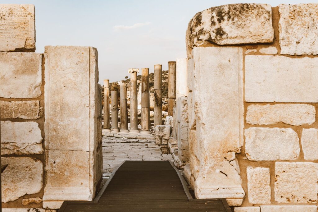 Explore ancient architecture with stone columns and ruins under a clear sky.