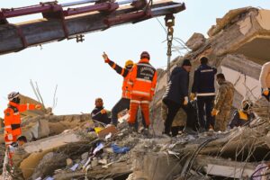 Rescue workers searching through rubble after an earthquake, showcasing teamwork and determination.