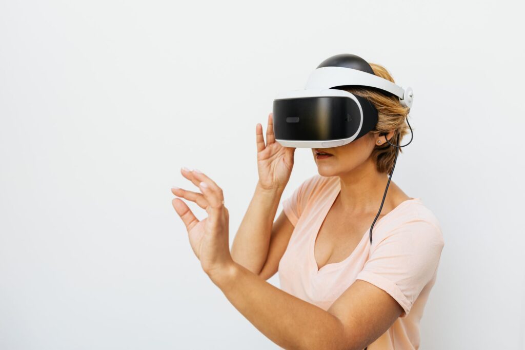 Woman using a VR headset immersed in a virtual reality world, with a white background.