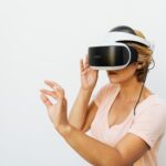Woman using a VR headset immersed in a virtual reality world, with a white background.