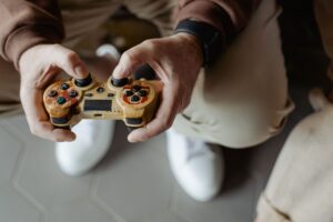 A person playing video games with a vintage-style controller indoors.