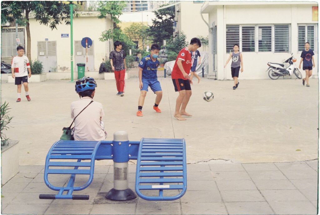 Group of children playing soccer on an urban street, enjoying outdoor activity.