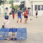 Group of children playing soccer on an urban street, enjoying outdoor activity.
