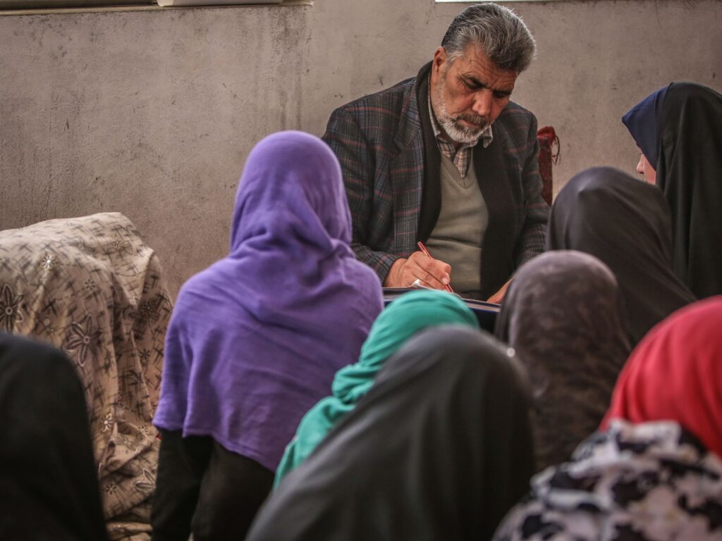 An educational session featuring a teacher and students in a classroom setting, highlighting cultural learning practices.