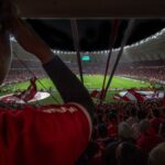 Lively soccer match at packed Brazilian stadium with cheering fans and vibrant atmosphere.