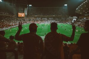 A vibrant football match with fans cheering in an illuminated stadium.