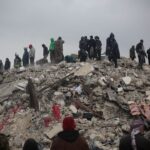 Survivors and rescuers search through rubble after a disaster in Idlib, Syria.