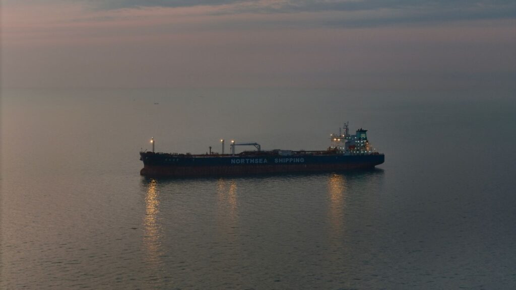 Oil tanker 'Northsea Shipping' sailing on calm waters during twilight, reflecting a serene scene.