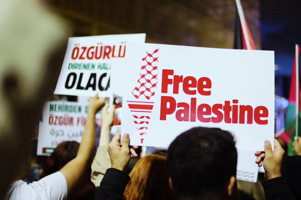 Protesters holding signs advocating for Palestine freedom at a rally.