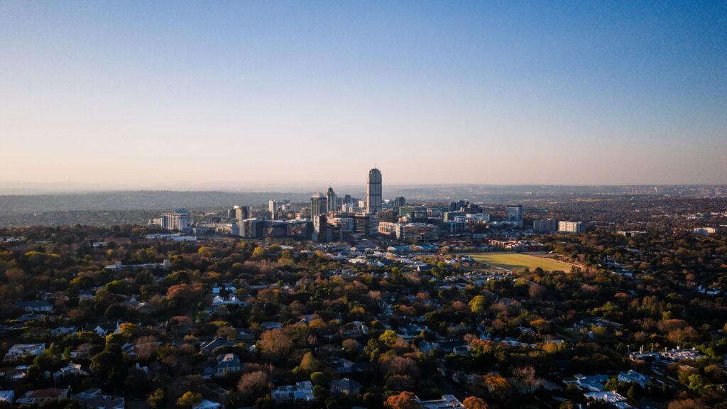 Stunning aerial view of Sandton, Gauteng, showcasing urban skyline and suburban layout under a clear sky.