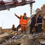 Rescue workers searching through rubble after an earthquake, showcasing teamwork and determination.