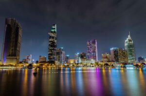 A breathtaking night view of Ho Chi Minh City's skyline with illuminated skyscrapers and reflections on the river.