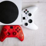 Close-up of red and white game controllers placed on a gaming console, top-view angle.