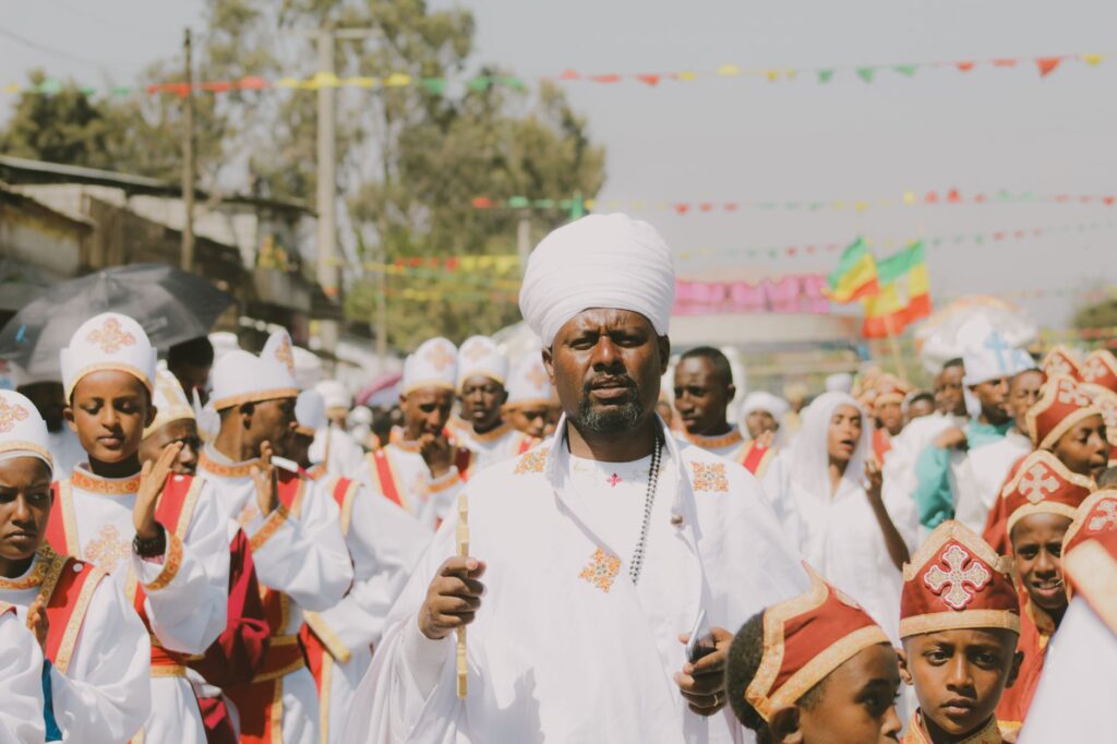 A vibrant parade of Ethiopian Orthodox Christians in traditional clothing during a religious festival in Addis Ababa.
