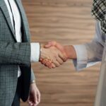 Close-up of a handshake between two men in business attire, symbolizing cooperation and partnership.