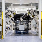 High-tech robots assembling a car in a modern factory setting, showcasing automation.