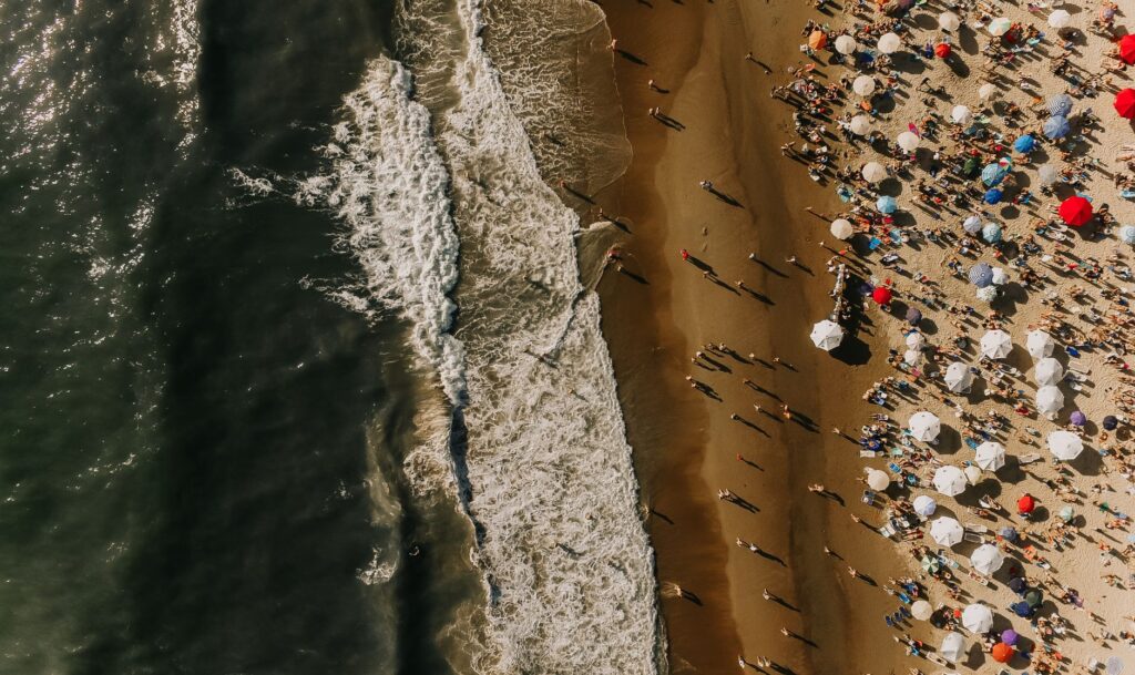 A vibrant aerial shot of Punta del Este beach with sunbathers and colorful umbrellas.