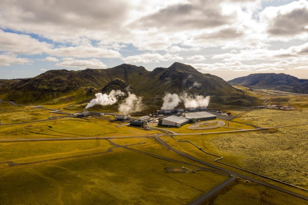 Aerial view of Hellisheidi geothermal power plant with mountains and steam in Iceland