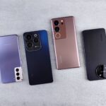 Top view of four colorful smartphones laid out on a white background, showcasing modern technology.