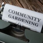 A vintage typewriter with a paper showing the text 'Community Gardening'.